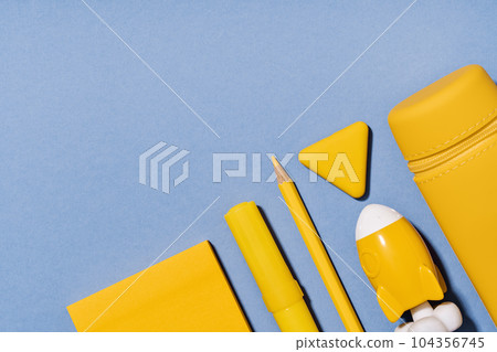 Assorted office and school yellow stationery on lilac blue. copy space for back to school or education craft office work concept. Bright Yellow rocket. Achievement and success. Top view 104356745