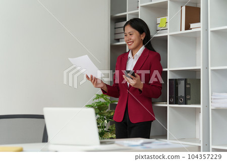 Smiling Asian Accountant person analyze financial report and studies annual figures, analyzes profits Smiling Asian Accountant person analyze financial report and studies annual figures, analyzes profits 104357229