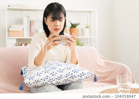 Asian woman play game online with live broadcasting via internet on smartphone.  104358047