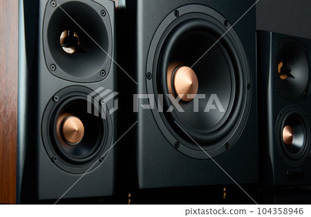 Multimedia acoustic sound speakers. Sound audio system with two satellites and subwoofer on dark background. Stereo system for listening music 104358946