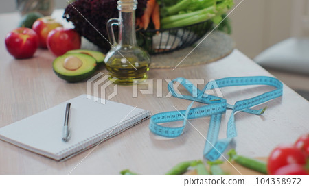 Measuring tape on table with fresh fruits and vegetables. Weight loss and diet concept. The concept of healthy eating and diet. 104358972