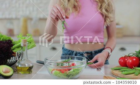 Close up young girl in the process of preparing healthy food. Healthy eating and cooking concept. 104359010