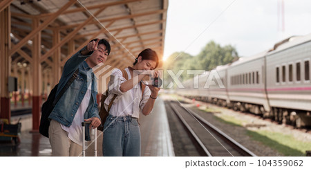 Asian couple at railway station have happy moment. Tourism and travel in the summer Asian couple at railway station have happy moment. Tourism and travel in the summer 104359062