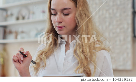 Close up of woman in the kitchen checking a shopping list on a notebook at home. Healthcare concept. Organic fresh fruit and vegetables. Dieting Concept. Close up of woman in the kitchen checking a shopping list on a notebook at home. Healthcare concept. Organic fresh fruit and vegetables. Dieting Concept. 104359182