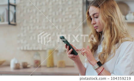 Young girl cooking healthy food salad using mobile cookbook apps in home kitchen. Healthcare concept. Organic fresh fruit. 104359219