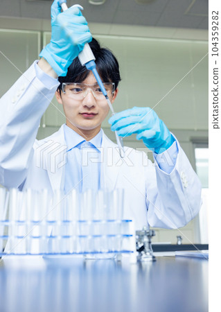 一個穿白大褂的男人在實驗室裡做實驗 104359282