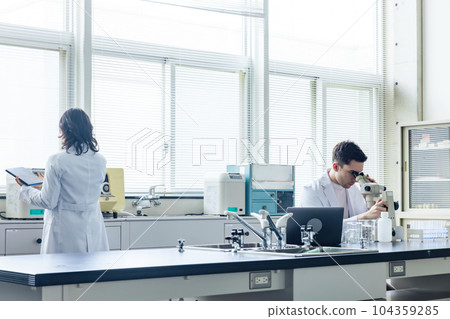 Multinational researcher group experimenting in laboratory 104359285