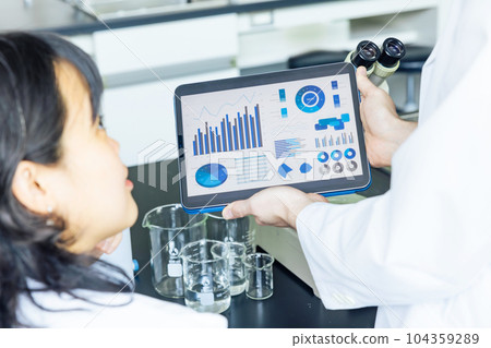 Researcher looking at data on tablet in lab 104359289