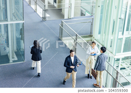 A multinational business group having a conversation in the lobby Bird's-eye angle A multinational business group having a conversation in the lobby Bird's-eye angle 104359300