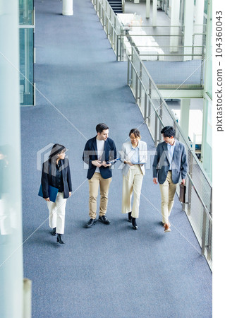 A multinational business group walking through the lobby Bird's eye angle 104360043