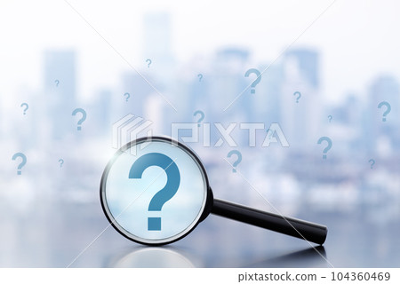 An image of doubts and questions about work. A magnifying glass and many question marks on a background of buildings. An image of doubts and questions about work. A magnifying glass and many question marks on a background of buildings. 104360469