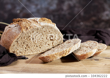 Golden bread next to ears of wheat on a table 104362222