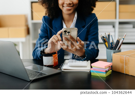 Young woman holding a smartphone, tablet showing payment success and credit card with yellow parcel box as online shopping concept . Young woman holding a smartphone, tablet showing payment success and credit card with yellow parcel box as online shopping concept . 104362644