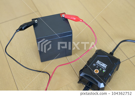 12V lead battery and charger during charging 12V lead battery and charger during charging 104362752