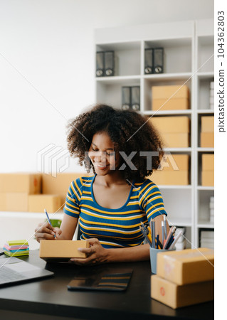 Small business entrepreneur SME freelance African woman working at home office, BOX,tablet and laptop online, marketing, packaging, delivery, e-commerce concept Small business entrepreneur SME freelance African woman working at home office, BOX,tablet and laptop online, marketing, packaging, delivery, e-commerce concept 104362803