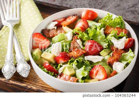 Strawberry avocado salad with feta, bacon and lettuce close-up in a bowl. Horizontal Strawberry avocado salad with feta, bacon and lettuce close-up in a bowl. Horizontal 104363244