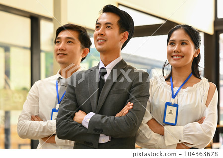 Confident business people keeping arms crossed and looking away while standing in office Confident business people keeping arms crossed and looking away while standing in office 104363678