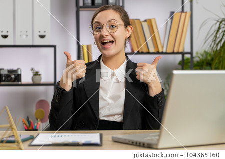 Happy business woman looking approvingly at camera showing thumbs up, like positive sign, good news Happy business woman looking approvingly at camera showing thumbs up, like positive sign, good news 104365160