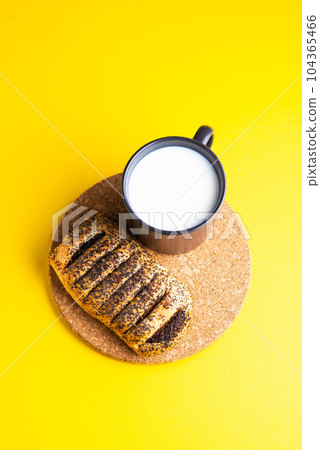 Breakfast bread and a cup of milk on yellow and blue background 104365466