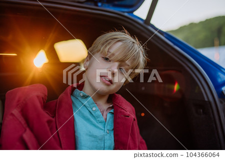 Close up of little boy sitting in a car trunk. Close up of little boy sitting in a car trunk. 104366064