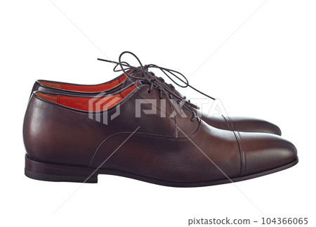 Beautiful pair of classic men's shoes made of high-quality brown leather, lace-up, with a leather sole, isolated on a white background. Side view. Beautiful pair of classic men's shoes made of high-quality brown leather, lace-up, with a leather sole, isolated on a white background. Side view. 104366065