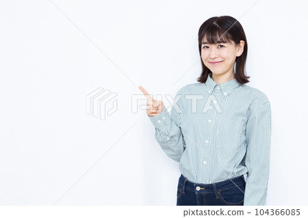 A woman in her thirties who raises her index finger in front of a white background A woman in her thirties who raises her index finger in front of a white background 104366085