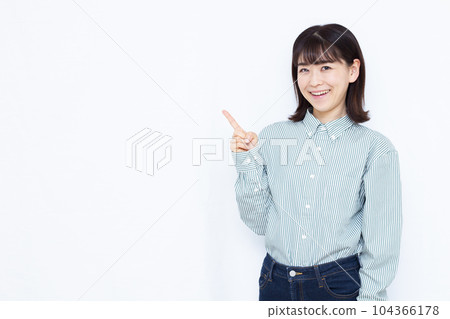 A woman in her thirties who raises her index finger in front of a white background A woman in her thirties who raises her index finger in front of a white background 104366178