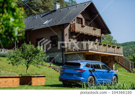 Close up of electric car chaging in a family garden. 104366180
