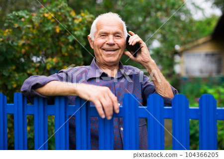 Old man talking on phone outdoors 104366205