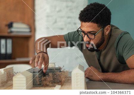 Young architect hard working on design of new house, building. 104366371