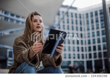 Portrait of young fashionable woman in a city with digital tablet. Portrait of young fashionable woman in a city with digital tablet. 104366396