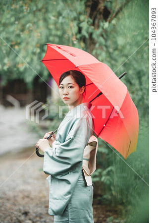 穿著日式服裝的年輕女子在大自然中撐著紅傘 穿著日式服裝的年輕女子在大自然中撐著紅傘 104367093