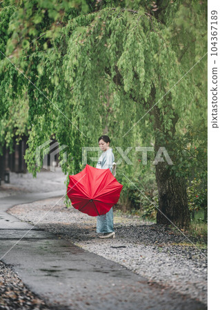 Young woman in Japanese clothes standing under the willow tree Young woman in Japanese clothes standing under the willow tree 104367189