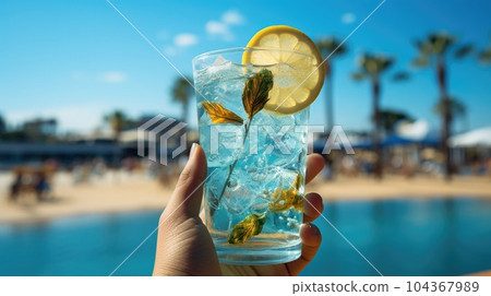 Blue refreshing cocktail at the beach in the woman hand on tropical beach background. Blue refreshing cocktail at the beach in the woman hand on tropical beach background. 104367989