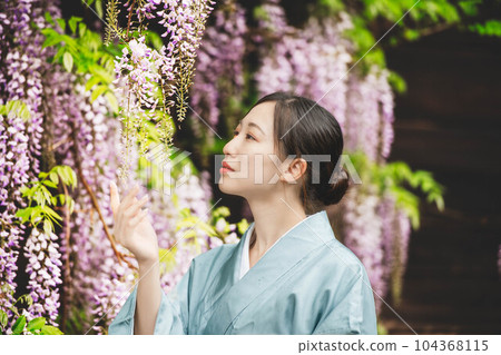 Young woman wearing wisteria flowers and kimono 104368115