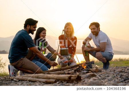Group of men and woman friends with multi-ethnic enjoy to party and stay surrounded by fire Group of men and woman friends with multi-ethnic enjoy to party and stay surrounded by fire 104368196