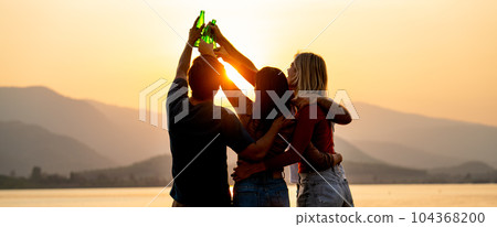 Silhouette of group of friends with multi-ethnic hug together also hold bottle of drinking Silhouette of group of friends with multi-ethnic hug together also hold bottle of drinking 104368200