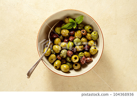 Different color of marinated olives in a bowl, top view Different color of marinated olives in a bowl, top view 104368936