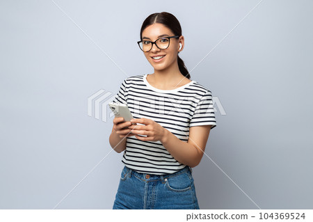 Portrait of a beautiful student using phone and earphones for learning. improving with technology 104369524