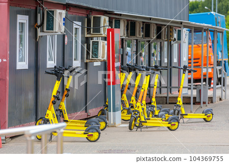 Parking electric scooters at a railway station. 104369755