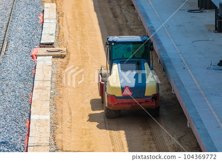 A construction roller tamping down sand at a construction site. Station construction. 104369772
