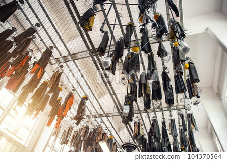 Scenic bottom view old abandoned coal mine worker clothing dressing room hanged at ceiling with chain lockers. Historical industrial mining museum Goslar tour. Industry decay recession concept Scenic bottom view old abandoned coal mine worker clothing dressing room hanged at ceiling with chain lockers. Historical industrial mining museum Goslar tour. Industry decay recession concept 104370564