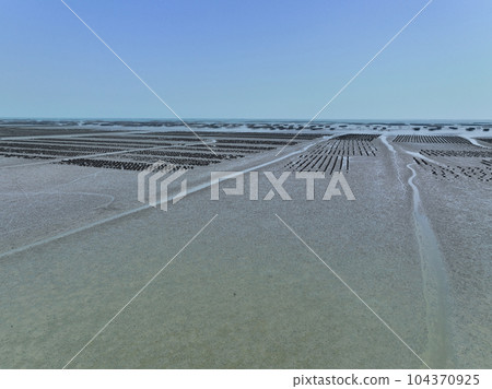Aerial view of Oyster farm. Sustainable farming. Oyster farming is an aquaculture practice. Oyster farming at Ang Sila town, Chonburi, Thailand. Landscape oyster beds at low tide on summer sunny day. 104370925