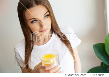 Woman Drinking Summer Refreshing Fruit Flavored Infused Water With Fresh Organic Lemon 104370948