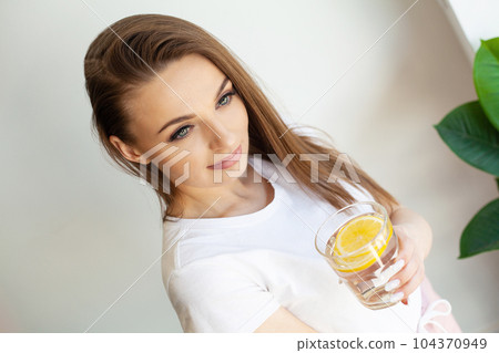 Woman Drinking Summer Refreshing Fruit Flavored Infused Water With Fresh Organic Lemon 104370949