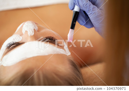 Young beautiful girl receiving facial mask in spa beauty salon 104370971
