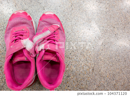 pair of worn out children's sneakers with scuffs damaged straps. pair of worn out children's sneakers with scuffs damaged straps. 104371120