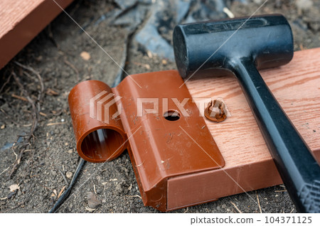 Assembling a raised bed garden panel with plastic connectors using a rubber mallet. Assembling a raised bed garden panel with plastic connectors using a rubber mallet. 104371125