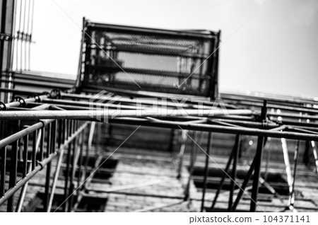 scaffolding erected along the outside of an old building looking up to the sky. scaffolding erected along the outside of an old building looking up to the sky. 104371141