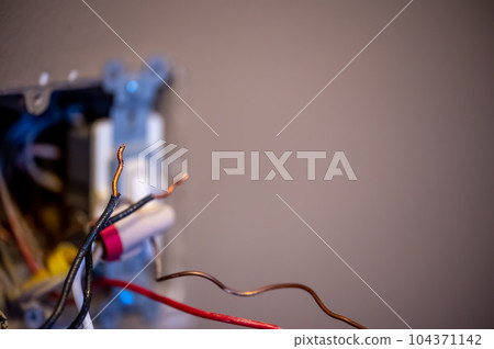 Selective focus on bare wire on an electrical project that is a shock hazard. 104371142